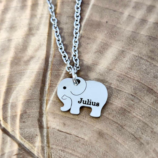 Hopeanvärinen kaulakoru elefantti laatalla, ja lapsen nimellä Julius

