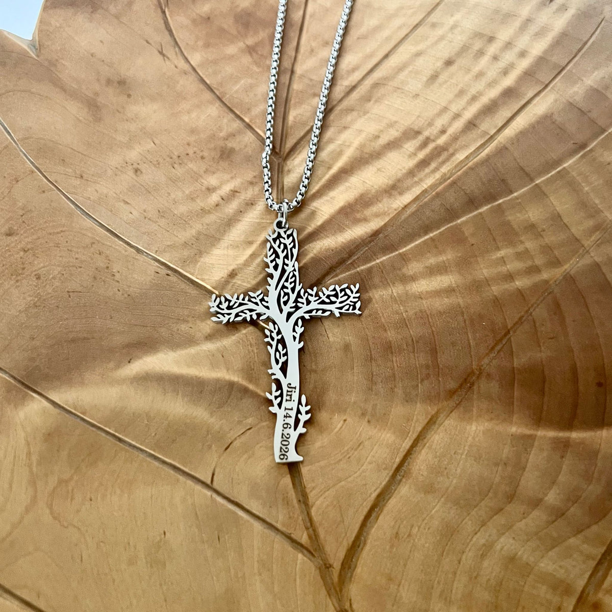 Kaunis ja ajaton rippiristi, jossa elämänpuu‑symboli pojalle.